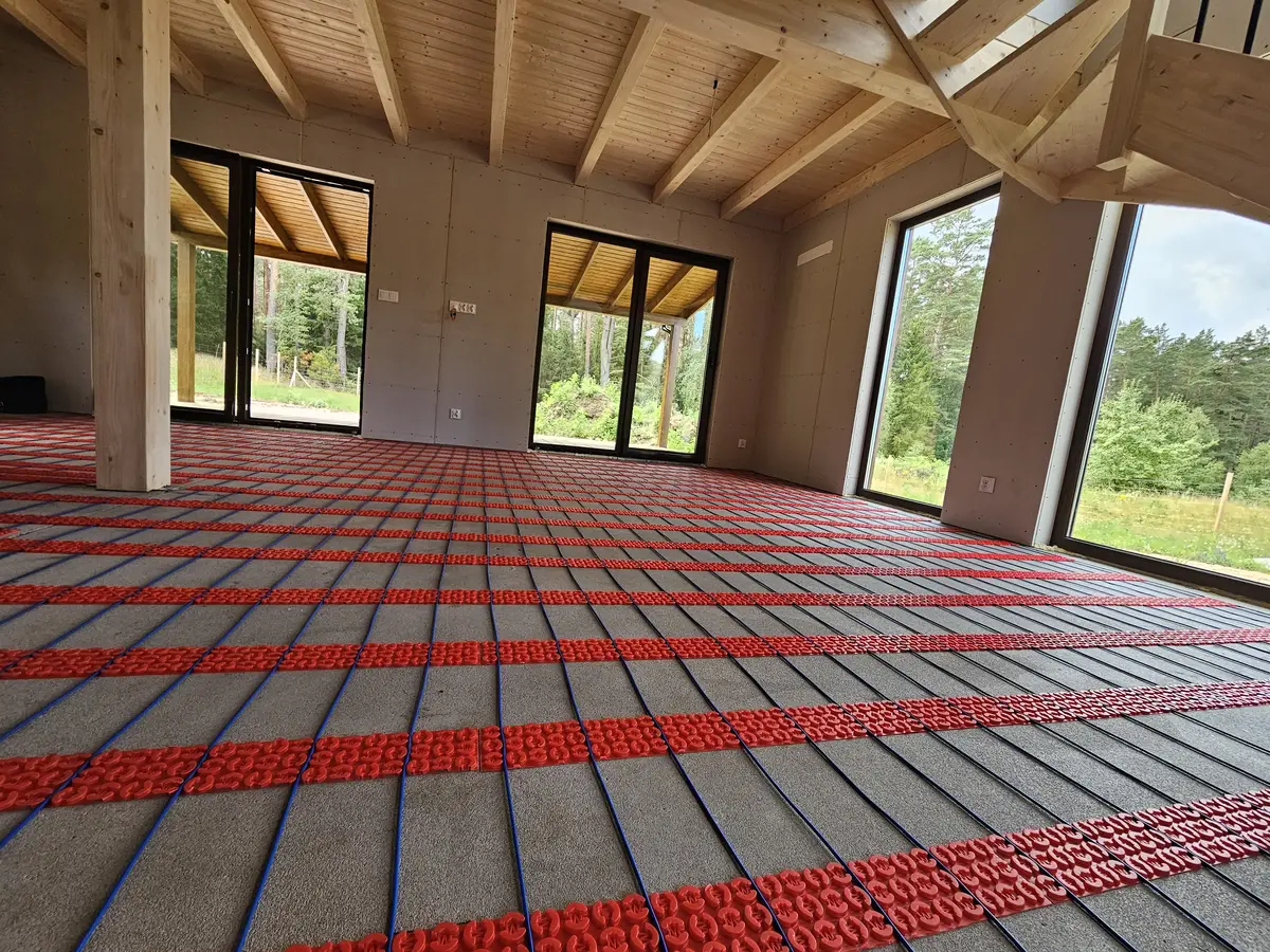 Kabel DCM-PRO prowadzony w paskach membrany, między nimi widoczna posadzka betonowa